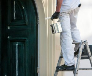 Close-up of a professional house painter with paint and brush